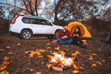 couple at camping site sitting near bonfire