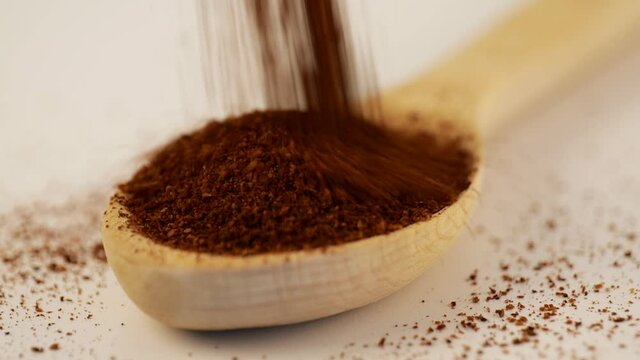 Dry sumac strewed from above into a wooden scoop
