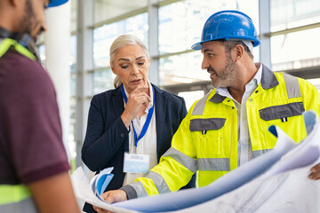 Mature engineer and contractor woman discussing at construction site