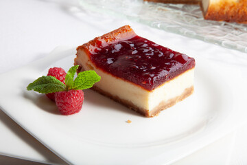 Tarta de queso  con base de galleta y frambuesa, porción . Cheesecake with a biscuit and raspberry base, portion.