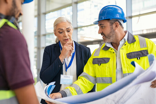 Mature Engineer And Contractor Woman Discussing At Construction Site