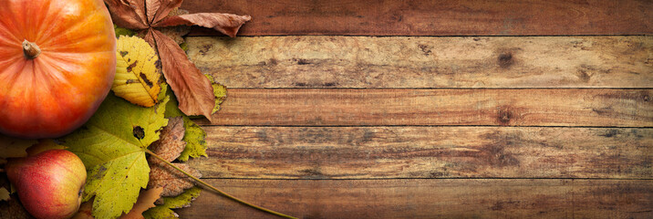 A Thanksgiving autumn harvest background of pumpkins, pears and leaves on a rustic wooden table...
