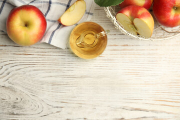 Natural apple vinegar and fresh fruits on white wooden table, flat lay. Space for text