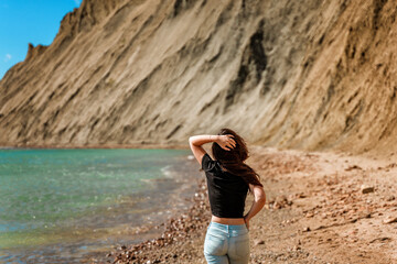 A young woman walks on an empty beach on Cape Chameleon in Crimea