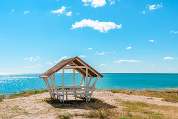 Fototapeta premium Cozy wooden picnic house on the seashore with a beautiful summer landscape with blue sky, Crimea