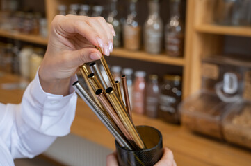 A woman holds a jar of reusable steel tubes. Eco concept