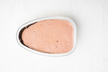 Liver pate, pasty spread in tin can, on white stone table background, top view flat lay