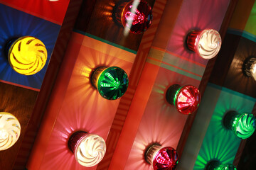 Array of colored light bulbs glowing in different colors on colored wooden frame