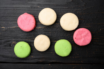 Macaroons. Delicious french desserts, on black wooden table background, top view flat lay
