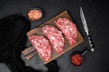 Ground raw meat patties. Meat patty, on black dark stone table background, top view flat lay
