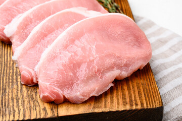 Raw organic meat. Pork steaks, fillets for grilling, baking or frying, on white stone table background