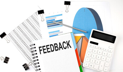 Obraz premium Text FEEDBACK on a notebook on the diagram and charts with calculator and pen