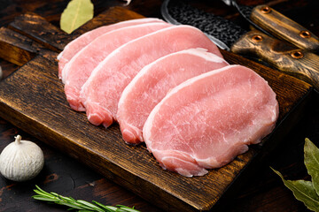 Raw organic meat. Pork steaks, fillets for grilling, baking or frying, on old dark  wooden table background