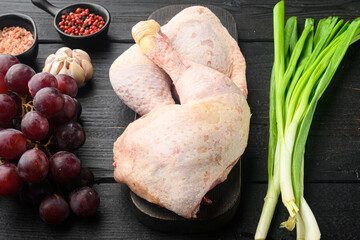 Sweet chicken surprise ingredients, with grape and parsley, on wooden cutting board, on black wooden table