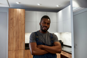 Self-confident diverse handyman in stylish kitchen interior
