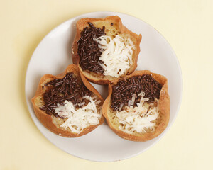 Mini moonlit cake with chocolate and cheese topping. This cake is very easy to find along the roadside. This cake is suitable to be eaten at night as a snack with the family. Focus blur.