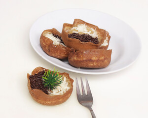 Mini moonlit cake with chocolate and cheese topping. This cake is very easy to find along the roadside. This cake is suitable to be eaten at night as a snack with the family. Focus blur.