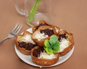 Mini moonlit cake with chocolate and cheese topping. This cake is very easy to find along the roadside. This cake is suitable to be eaten at night as a snack with the family. Focus blur.