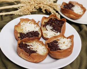 Mini moonlit cake with chocolate and cheese topping. This cake is very easy to find along the roadside. This cake is suitable to be eaten at night as a snack with the family. Focus blur.