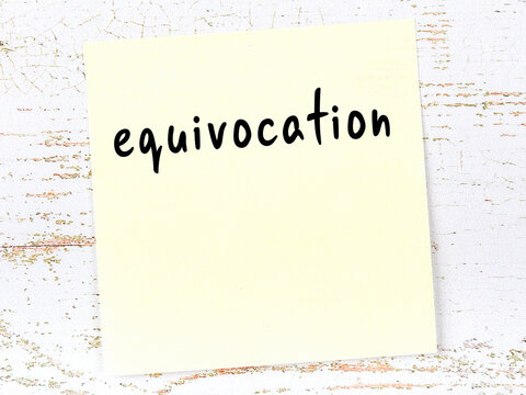 Yellow sticky note on wooden wall with handwritten word equivocation