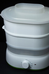 Food Steamer on a black background. Household appliances for healthy food preparation.