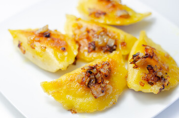Fried dumplings sprinkled with fried onion, traditional Polish, Russian and Ukrainian cuisine