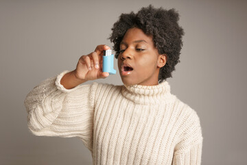 Young African American teen with asthma inhaler