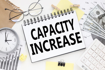 Capacity Increase. Notepad on White Background Financial charts. business concept