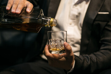 Businessmen in suits drinking whiskey