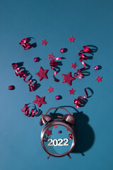 Merry Christmas happy new year flat lay with alarm clock, stars, streamers number 2022 vertical format