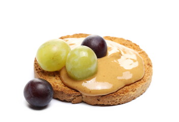 Peanut butter spread on slice of bread with fresh fruit grapes isolated on white background