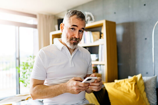 Man At Modern Loft Home Using Mobile Phone