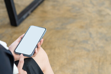 Female hand holding smartphone with blank white screen and space for text Use a mobile shopping app. Check social media news, send mobile SMS messages, order food, deliver food sitting on the couch at