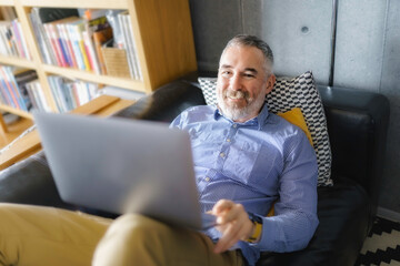 Portrait of handsome man with laptop on sofa