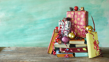 stack of books with christmas balls, gift, present christmas decoration,giving a book for...