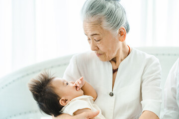 赤ちゃんを抱っこするシニア女性