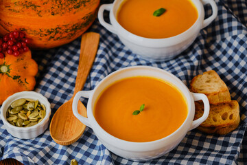 Homemade pumpkin soup with cream and basil