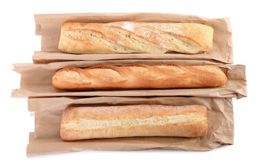 Different tasty baguettes and packages on white background, top view. Fresh bread