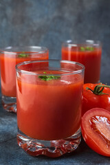 Tomato juice in glasses. Blue vintage background. Rustic.