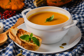 Homemade pumpkin soup with cream and basil