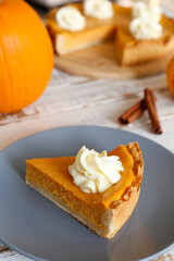 Traditional thanksgiving food on wooden table. Orange delicious homemade pumpkin pie with crust and decorative items. Thanksgiving table setting concept.Top view, close up, copy space, background.