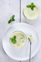 Green Tea Pana cotta in a glass decorated with mint leaf.
