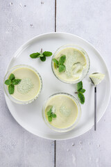 Green Tea Pana cotta in a glass decorated with mint leaf.