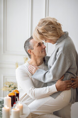 adult man and woman hugging sitting near a round festive table