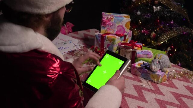 Santa Claus is using the green screen of the tablet for shopping.Tablet with a green screen.4k