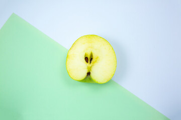 Close up photo of Green Apple Fruit on the white and green background. Minimalism, original and creative image. Beautiful natural wallpaper.