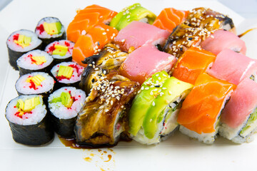 Tasty Colorful assorted Set of different type Sushi. Dinner in Japanese style. Healthy food. Filadelfia and Maki sushi rolls with Avocado, Tuna, Salmon, fish and Prawns. Close up view. Wallpaper.