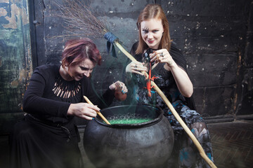 Young beautiful witches preparing a potion for Halloween 