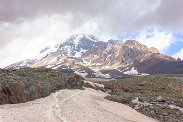Mountain landscape with clouds and snow. View of Kazbek in the clouds from the Gergeti glacier