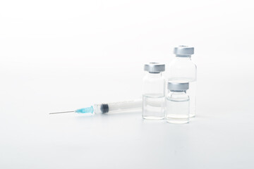 Syringes and glass bottles in white background